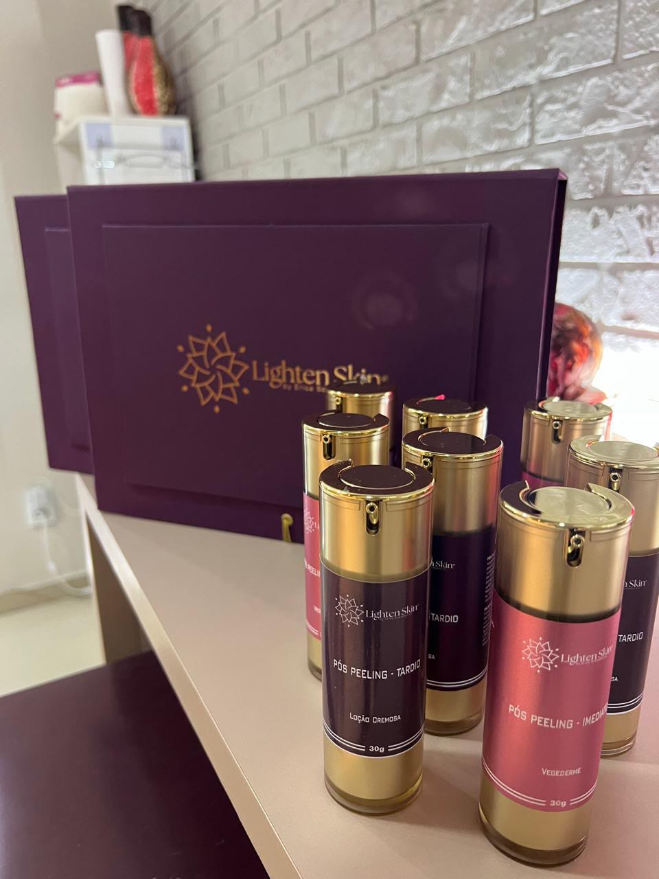 Frascos pós-peeling com tampas douradas diante da caixa Lighten Skin